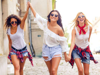 Korte broeken gids – Drie vrouwen in korte broeken lopen door de stad.