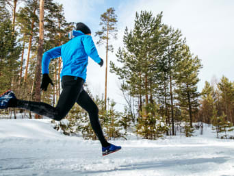 Laufen im Winter: Mann läuft auf einer schneebedeckten Strecke.