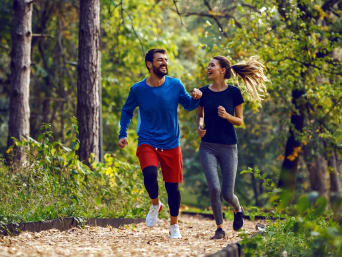 Lauftechnik verbessern – Freunde joggen gemeinsam im Wald.