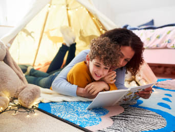 První čtení pro děti: Matka a syn čtou společně v pohodlí dětského pokoje.