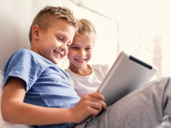 Kinder lernen Lesen mithilfe einer Lese-App auf dem Tablet.