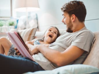 Un père et sa fille lisent un livre ensemble.