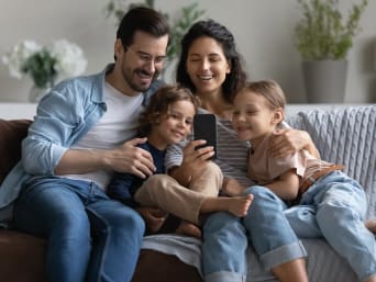 Smartphone für Kinder – Familie schaut zusammen auf ein Smartphone.