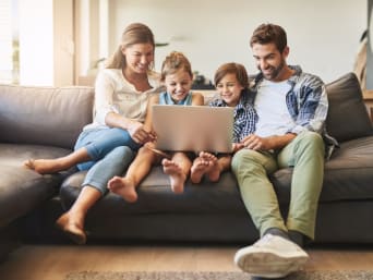 Bezpieczne korzystanie z Internetu – rodzina siedzi przed laptopem i wspólnie surfuje w Internecie.
