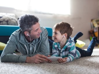Un père et son fils écoutent de la musique sur un appareil multimédia.
