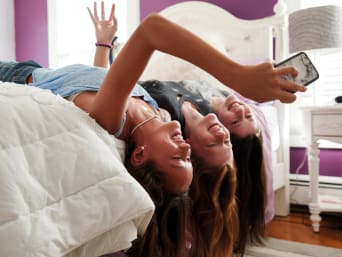 Vantaggi dei social network: tre ragazze fanno un selfie e si divertono a postarlo. 