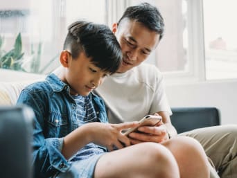 Zagrożenia w mediach społecznościowych – tata tłumaczy synowi ustawienia prywatności w aplikacji.