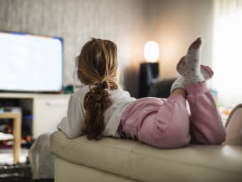 Netflix Kindersicherung – Kleines Mädchen schaut allein Fernsehen.