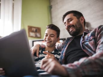 YouTube Kindersicherung – Vater und Sohn schauen zusammen Online-Videos auf dem Computer.