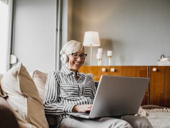 Hobby’s online – oudere vrouw chat met anderen via haar laptop.