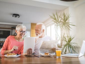 Internetsicherheit – älteres Paar liest während des Frühstücks auf einem Tablet.