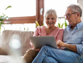 Veilig surfen - ouder echtpaar zit op de bank met een laptop.