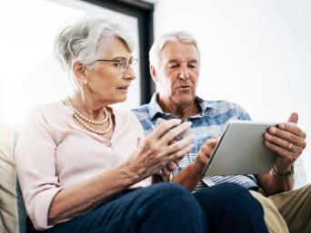 Seniorzy zapoznają się z bankowością internetową za pośrednictwem tabletu.  