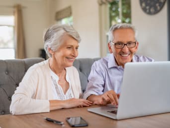Ouder echtpaar kijkt samen rond in een online winkel.