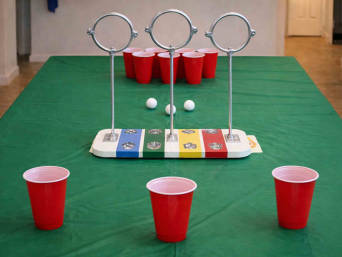 Tisch-Quidditch für den Harry Potter Geburtstag - Drei Ringe aufgestellt in der Mitte des Tisches und Becher auf beiden Seiten.