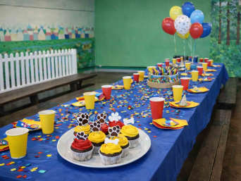 PAW-Patrol-Geburtstag: gedeckter Tisch, PAW-Patrol-Cupcakes und Ballons.