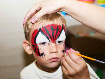 Spiderman-Party: Kind bekommt Gesicht als Spiderman bemalt. Spiderman-Party: Kind bekommt Gesicht als Spiderman bemalt.