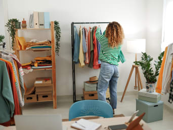 Minimalismo stile di vita: una donna riordina i vestiti nel suo appartamento minimalista.