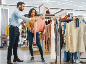 Modemanagement Ausbildung: Store Manager berät eine Kundin bei der Kleidungswahl.