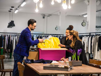 Métiers de la mode : la responsable de magasin et les vendeurs textiles contrôlent les nouveaux vêtements.