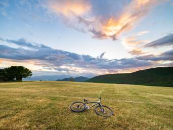 MTB Sibillini: mountain bike poggiata su un prato nelle Marche. MTB Sibillini: mountain bike poggiata su un prato nelle Marche.
