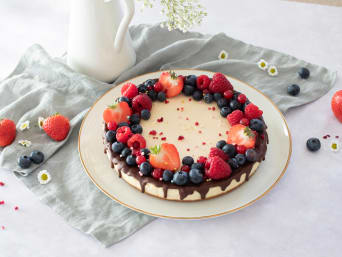 Receta de postre para el Día de la Madre: tarta de queso con frutas y glaseado de chocolate.