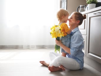 Idee Festa della Mamma: un piccolo sorprende la sua mamma con un mazzo di fiori.