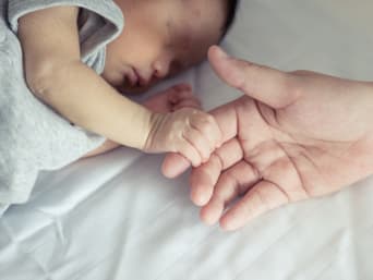 Cómo vestir a un bebé para dormir: una madre y su bebé duermen juntos.