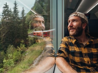 Mezzi di trasporto ecologici: uomo fa un viaggio sostenibile in treno.