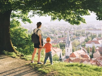 Vacanza sostenibile: madre e figlio ammirano la città di Lubiana durante un tour turistico.