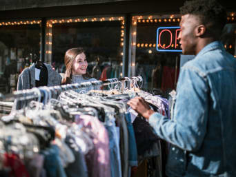 Vêtements occasion : deux amis découvrant des vêtements vintages dans une friperie.