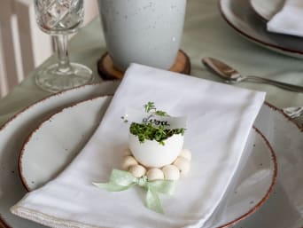 Dekoracje stołu wielkanocnego – samodzielnie zrobiona tabliczka imienna ze skorupki po jajku i rzeżuchy.