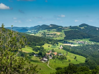 Juragebirge: Blick auf das Schweizer Juragebirge mit Wäldern und kleinen Dörfern.