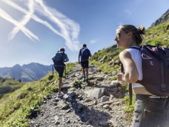 Jura Höhenweg: Gruppe von jungen Leuten wandert einen felsigen Weg hinauf.