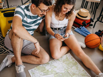 Planowanie aktywnych wakacji: młoda para wybiera najlepszą trasę na wędrówkę.