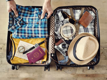 Voyager avec bagage cabine seulement : un homme prépare sa valise pour le voyage en avion.