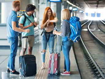 Backpack, suitcase or holdall: a group of people waiting on a platform with their pieces of luggage.