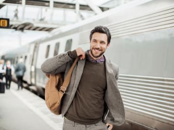 Tenue de voyage homme : un homme sur le quai porte une tenue élégante pour voyager.