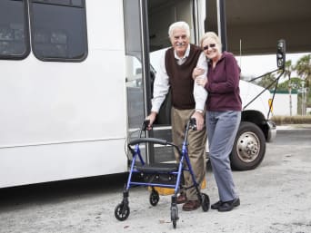 Viaggi per persone con disabilità motorie: coppia di anziani pronti per partire in bus.  