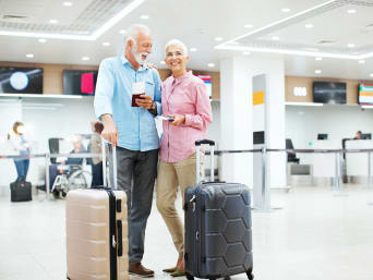 Viaggi organizzati per pensionati – Una coppia in terza età aspetta in aeroporto.