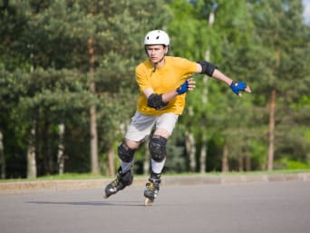 Patinaje en línea para principiantes: un patinador equipado con elementos de protección patina por la calle.