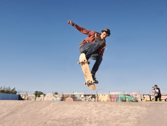Jazda na deskorolce: skateborder wykonuje akrobacje w skateparku. 