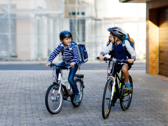 Rowerem do szkoły: dwóch chłopców jedzie bezpiecznie na rowerze do szkoły. 