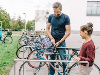 De weg naar school op de fiets – Vader begeleidt zijn dochter op de fiets naar school