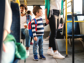 Autobus szkolny – mama z synem jadą razem do szkoły autobusem.