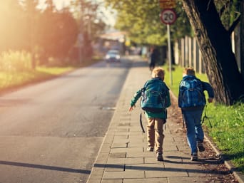 Bezpieczna droga do szkoły pieszo: dzieci biegną chodnikiem.