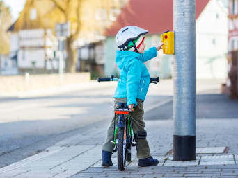 Bambino in bicicletta aspetta al semaforo