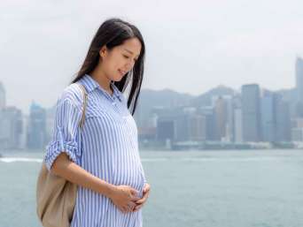 Fashion for pregnancy: a pregnant woman wearing a printed dress. Fashion for pregnancy: a pregnant woman wearing a printed dress.