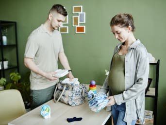 Ab wann Kliniktasche packen: Pärchen packt rechtzeitig vor dem Entbindungstermin die Kliniktasche.