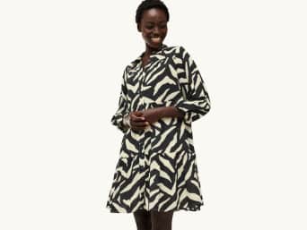 Stylish pregnancy fashion: a woman wearing a printed wrap dress to hide her pregnancy bump. Stylish pregnancy fashion: a woman wearing a printed wrap dress to hide her pregnancy bump.